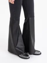 Jeans bootcut negros de denim elastizado con botamanga ancha confeccionada en cuero negro al tono.