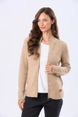 Campera tejida de abrigo color beige, con cierre frontal, cuello alto y bolsillos laterales.