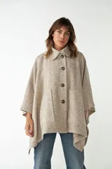 Capa con cuello, cierre frontal con botones y bolsillos delanteros. Confeccionada en lana fina sin teñir, diseñada exclusivamente por Don Baez.