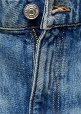Pantalón de jean celeste de tiro medio, corte recto, cinco bolsillos y tachuelas decorativas.