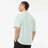 Camisa verde de manga corta con cuello clásico y cierre con botones.