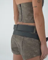 Short marrón de tiro alto con cinturón doble negro con hebillas plateadas.