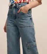 Pantalón cargo de jeans con lavado dirty, corte holgado, bolsillos laterales y trabillas en la cintura.