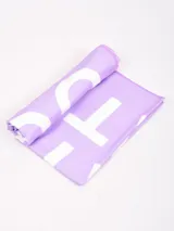 Toalla de playa de microfibra color lila con estampado de letras blancas.