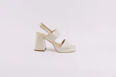 Sandalias de plataforma color crema, con tiras anchas de charol y hebilla ajustable en el tobillo.