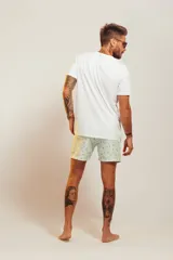 Bañador de hombre color rosa pálido con estampado de golondrinas oscuras. Presenta cintura elástica con cordón ajustable de color crudo y terminales turquesa.