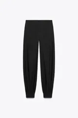 Pantalón de tiro medio confeccionado en hilatura con mezcla de viscosa, color negro. Presenta bolsillos laterales ocultos en costura, bajo acabado en puño con botones y cierre frontal con cremallera, botón y ganchos metálicos.