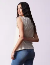 Blusa color crema en tejido elastizado, con aplique de puntilla en las sisas y abertura con botón en la espalda.