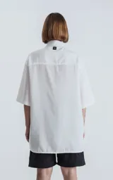 Camisa blanca de corte amplio con mangas cortas.