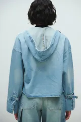 Chaqueta de jean celeste con capucha, cierre frontal con botones y mangas largas con puños anchos.