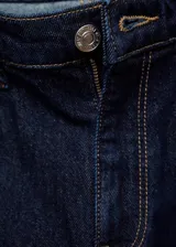 Pantalón de jean azul oscuro, tiro alto, corte mom fit, con cinco bolsillos y cierre de cremallera y botón.