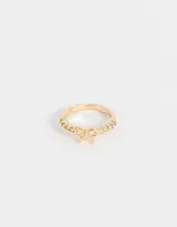 Anillo dorado con strass y un moño de metal.