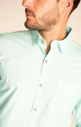 Camisa de manga larga color blanco, confeccionada en 100% algodón orgánico, con diseño liso y detalles de botones de madera.