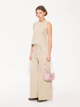Top color beige confeccionado en tejido de algodón con cuello a la base y recortes de entalle.