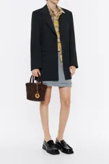 Bolso tipo tote de mimbre color marrón oscuro, con doble asa corta y correa de cuero marrón. Incluye dije circular dorado con letras grabadas.