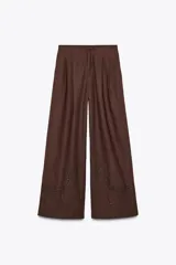Pantalón marrón de tiro alto con cintura elástica en la espalda, bolsillos laterales, pliegues en la parte delantera y bordados combinados a tono en el ruedo.