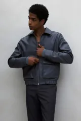 Pantalón de vestir negro de corte recto, con bolsillos laterales y traseros. Se ajusta a la cintura con cinturón.