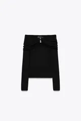 Top de punto negro con escote recto, hombros descubiertos, mangas largas y detalle de pieza metálica plateada en el delantero.