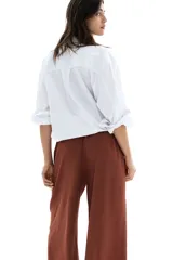 Pantalón marrón de punto texturado, corte holgado, tiro alto, piernas rectas, elástico en la cintura y cordón para ajustar.