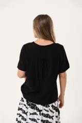 Blusa negra de corte holgado con mangas cortas.