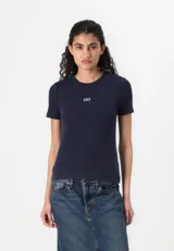 Remera de mujer color crema, de corte ajustado, con cuello redondo y logo de la marca bordado en el pecho.