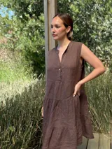 Vestido marrón de lino, corte midi, sin mangas, con cuello mao y botones de nácar.