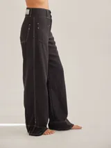 Pantalón negro de tiro medio alto, corte palazzo, con bolsillos delanteros y traseros.
