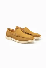 Mocasín color marrón claro, liso, de cuero, con suela de goma color crema.