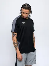 Remera deportiva Umbro de manga corta, color azul marino con paneles laterales y en las mangas de tela texturizada en tono azul más claro. Cuello redondo y logo Umbro bordado en el pecho.