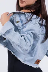 Campera de jean celeste de corte cropped, con cuello clásico, botones metálicos y mangas largas.