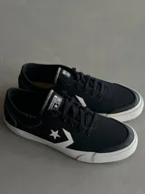 Championes Converse C All Star de lona negra con suela blanca, cordones negros y el logo de la estrella y el chevron en blanco en el lateral.