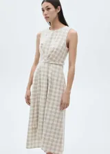 Vestido midi color crema con estampado de cuadros marrones, sin mangas, con cuello redondo y corte evasé.