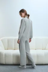 Cardigan gris claro con escote en V y cierre frontal con botones.