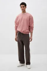Buzo rosa de tejido liviano de mezcla de algodón con interior cepillado suave, cuello redondo ribeteado, hombros caídos y remate ancho acanalado en puños y bajo. Corte holgado.