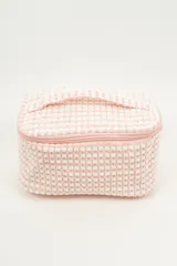 Neceser rectangular con cierre de cremallera, confeccionado en tejido de toalla con textura de motitas en color blanco y rosa pastel.