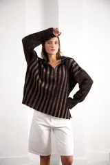 Buzo color beige con rayas horizontales en lurex dorado, cuello con medio cierre, corte oversized y logo tejido en el puño.