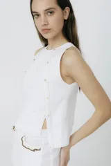 Musculosa color borgoña de lino, con cuello redondo y detalle de botones dorados en los hombros y laterales.