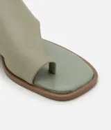 Sandalia plana tipo mule color crema, con puntera cuadrada, tira ancha en la parte superior y detalle de dedo.