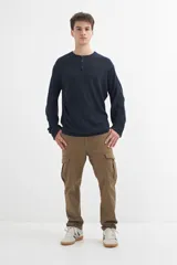 Sweater de punto azul marino, de corte recto y manga larga, con cuello redondo y tapeta con botones.