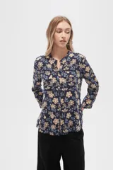 Camisa de viscosa con estampado floral en tonos azul, beige y blanco. Tiene cuello mao, mangas largas y bolsillos en el pecho.