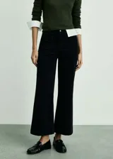 Pantalón culotte de pana color negro, tiro alto, con cierre de cremallera y botón, trabillas, dos bolsillos de parche delanteros y dos bolsillos de parche traseros.