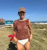 Musculosa tejida color marrón con diseño calado y flecos en los hombros.