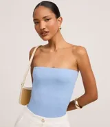 Top strapless (sin breteles) de color celeste claro, ajustado al cuerpo.