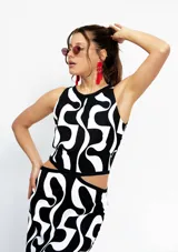 Vestido largo con estampado abstracto en blanco y negro, corte semi halter, aberturas laterales en la cintura y tajos laterales en la falda.