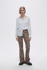 Camisa a rayas verticales grises y blancas, con cuello camisero, cierre frontal con botones, mangas largas con trabillas para enrollar y dos bolsillos de parche en el pecho.