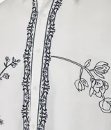 Camisa de manga corta confeccionada en algodón y lino, color blanco con bordado floral en negro.