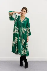 Vestido midi verde con estampado de hojas color crema, escote en V y mangas 3/4 amplias.