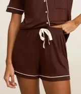 Conjunto de pijama americano corto color marrón con detalles en blanco, confeccionado en viscolycra. Incluye una blusa de manga corta con cuello solapa y abotonado delantero, y un short con cintura elástica y lazo.