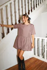 Vestido corto negro con corte en la cintura y falda balloon, de manga corta y cuello redondo.