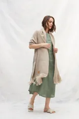 Chal color arena tejido en lana sin teñir, con flecos en los extremos.